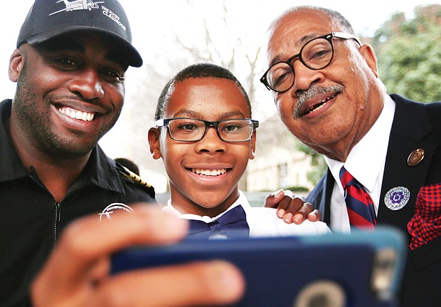 Nick Booker, a seventh-grader at Richmond Preparatory Christian Academy’s Douglass School, takes a selfie with aviator Barrington Irving, left, following Mr. Irving’s talk Wednesday to several hundred students at the Science Museum of Virginia. Also in the selfie is Elbert Brinson, dean of the Douglass School.