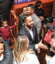 Delegate-elect Jeff M. Bourne, center, extends his hand to a well-wisher at his victory party Tuesday night in Shockoe Bottom after winning a special election for the 71st District seat for the House of Delegates. After resigning from the Richmond School Board, he was sworn in to his new office at noon Wednesday, joining 33 other Democrats in the House of Delegates.  