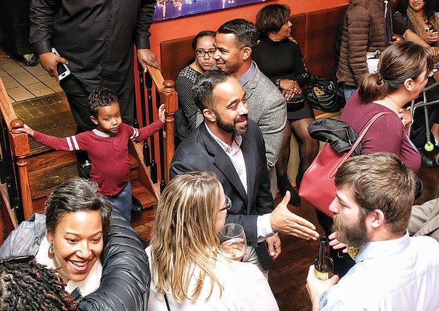 Delegate-elect Jeff M. Bourne, center, extends his hand to a well-wisher at his victory party Tuesday night in Shockoe Bottom after winning a special election for the 71st District seat for the House of Delegates. After resigning from the Richmond School Board, he was sworn in to his new office at noon Wednesday, joining 33 other Democrats in the House of Delegates.  