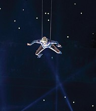 Singer-songwriter Lady Gaga makes a bold entrance suspended on wires from the rafters of NRG Stadium during her musical halftime performance at Super Bowl 51. Below, New England Patriots quarterback Tom Brady celebrates with the Vince Lombardi Trophy among the confetti and the roaring crowd after beating the Atlanta Falcons in a historic overtime victory in last Sunday’s Super Bowl 51. 