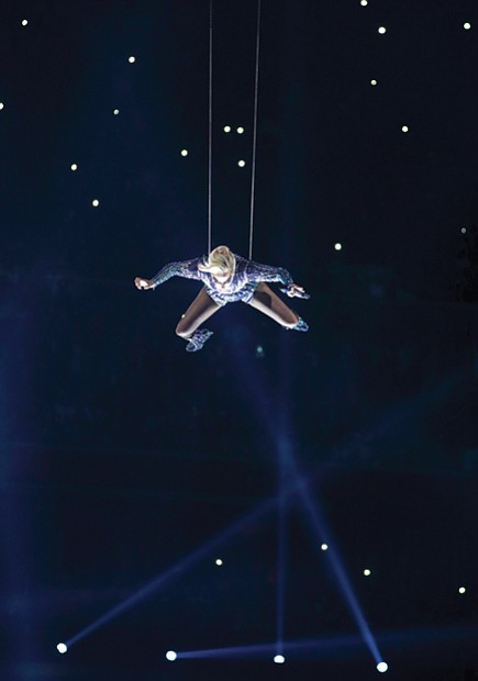 Singer-songwriter Lady Gaga makes a bold entrance suspended on wires from the rafters of NRG Stadium during her musical halftime performance at Super Bowl 51. Below, New England Patriots quarterback Tom Brady celebrates with the Vince Lombardi Trophy among the confetti and the roaring crowd after beating the Atlanta Falcons in a historic overtime victory in last Sunday’s Super Bowl 51. 
