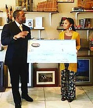 Freedom Ties Co-Founder Tavares Bethel presents a check to Maeva Jackson, founder of Black
World Books, who received the majority votes which awards her half the sales generated from
the December sales on FreedomTies.com.