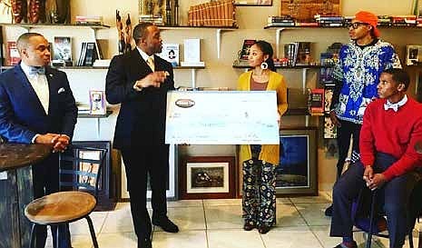 Freedom Ties Co-Founder Tavares Bethel presents a check to Maeva Jackson, founder of Black
World Books, who received the majority votes which awards her half the sales generated from
the December sales on FreedomTies.com.