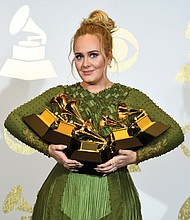 Adele holds all 
five of her Grammys, including one for Best Album.