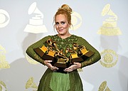 Adele holds all 
five of her Grammys, including one for Best Album.