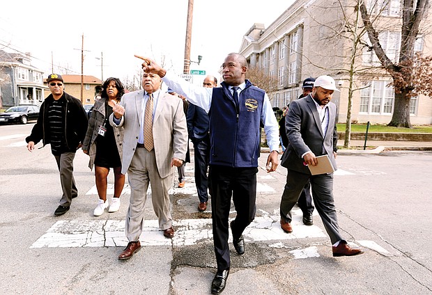 Checking the pulse of the city //
Richmond Mayor Levar M. Stoney, center, leads a group of about 40 people Wednesday during a tour of the Brookland Park Boulevard business corridor in North Side. Accompanied by City Council President Chris A. Hilbert, 3rd District, Mayor Stoney was shown buildings tagged with graffiti that need to be cleaned as well as Scott’s Funeral Home’s new chapel. The mayor also met business owners along the route, including including the proprietors of the renovated Two Pillars Tattoo and Sign Shop. Walking to his left is Richard A. Lambert Sr., president and owner of the funeral home. Saying he wants to be a “hands on, visible mayor,” Mayor Stoney plans to walk the Jefferson Davis Highway corridor in South Richmond next week with 8th District City Council member Reva M. Trammell.