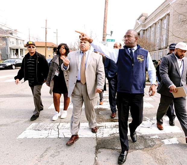 Checking the pulse of the city //
Richmond Mayor Levar M. Stoney, center, leads a group of about 40 people Wednesday during a tour of the Brookland Park Boulevard business corridor in North Side. Accompanied by City Council President Chris A. Hilbert, 3rd District, Mayor Stoney was shown buildings tagged with graffiti that need to be cleaned as well as Scott’s Funeral Home’s new chapel. The mayor also met business owners along the route, including including the proprietors of the renovated Two Pillars Tattoo and Sign Shop. Walking to his left is Richard A. Lambert Sr., president and owner of the funeral home. Saying he wants to be a “hands on, visible mayor,” Mayor Stoney plans to walk the Jefferson Davis Highway corridor in South Richmond next week with 8th District City Council member Reva M. Trammell.