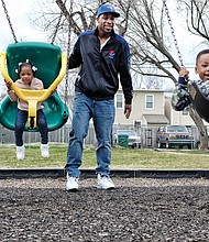 
Family fun //
Jamal Marshall and his children, Zuri, 2, left, and Jamal Jr., 4, take advantage of the springlike weather to enjoy family time on the swings at the George Mason Elementary School playground in Church Hill. Temperatures in Richmond are to soar into the 70s through Saturday.