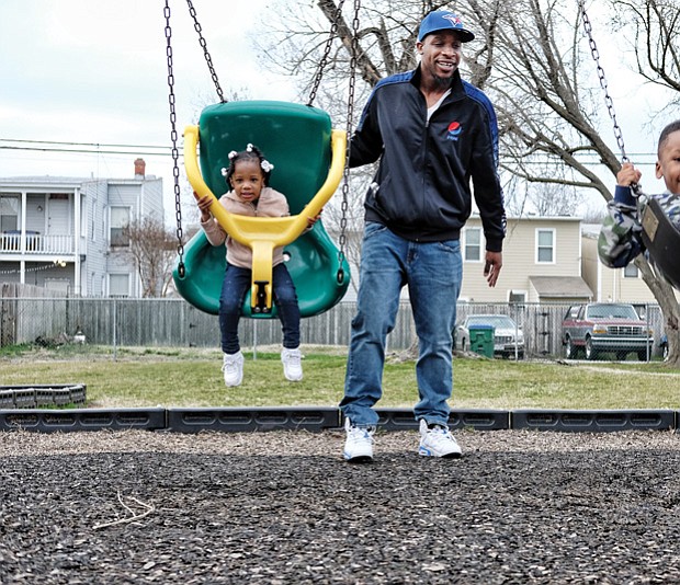 
Family fun //
Jamal Marshall and his children, Zuri, 2, left, and Jamal Jr., 4, take advantage of the springlike weather to enjoy family time on the swings at the George Mason Elementary School playground in Church Hill. Temperatures in Richmond are to soar into the 70s through Saturday.