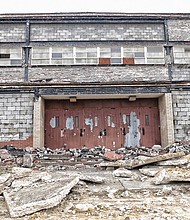 Sandra Sellars/Richmond Free Press 

Concrete rubble blocks the doors to the gym at the old Armstrong High School in the 1600 block of North 31st Street near Nine Mile Road in the East End. The school building is being torn down to make way for more than 270 apartments, townhouses and single-family homes on the 21-acre property. 
It is all part of the city-supported Church Hill North Revitalization project. Conceived under former Mayor Dwight C. Jones, razing the school is the first step toward replacing the Creighton Court public housing community located about a block away across Nine Mile Road. Some residents will move into the new apartments as work begins in Creighton Court. 
The Richmond Redevelopment and Housing Authority and a Boston-based nonprofit, The Community Builders, are spearheading the development. Just a few blocks south on Nine Mile Road, the city also is supporting development of new grocery, retail and residential project that is designed to complement the housing development.