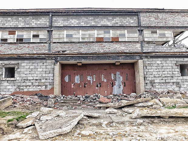 Sandra Sellars/Richmond Free Press 

Concrete rubble blocks the doors to the gym at the old Armstrong High School in the 1600 block of North 31st Street near Nine Mile Road in the East End. The school building is being torn down to make way for more than 270 apartments, townhouses and single-family homes on the 21-acre property. 
It is all part of the city-supported Church Hill North Revitalization project. Conceived under former Mayor Dwight C. Jones, razing the school is the first step toward replacing the Creighton Court public housing community located about a block away across Nine Mile Road. Some residents will move into the new apartments as work begins in Creighton Court. 
The Richmond Redevelopment and Housing Authority and a Boston-based nonprofit, The Community Builders, are spearheading the development. Just a few blocks south on Nine Mile Road, the city also is supporting development of new grocery, retail and residential project that is designed to complement the housing development.