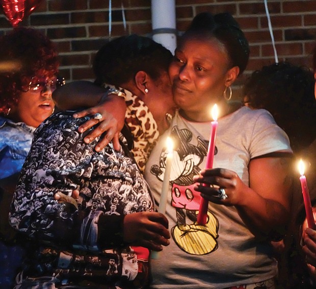 Victims mourned //
From left, LaTanya, China and Dequalla Walker join family, friends, neighbors and others at a candlelight vigil Monday evening to remember their sister, Shaquenda Walker, 24, and their mother, Deborah Walker, 55.