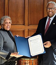 Richmond Free Press Publisher Jean P. Boone receives a citation from 4th District Congressman A. Donald McEachin — a copy of his remarks placed in the Congressional Record commemorating the newspaper’s 25th anniversary. 
The Congressional Record is the official record of the proceedings and debates of the U.S. House of Representatives and U.S. Senate. In remarks he delivered Feb. 13 on the House floor, Rep. McEachin lauded the independent, black-owned Free Press as a “voice for all people since its inception.” He recalled the newspaper’s late founder, Raymond H. Boone, and noted that the Free Press “has altered the media landscape of Richmond, the former capital of the Confederacy,” with its award-winning coverage. 
The Free Press, he said, “does not only chronicle history, it has made history for the last 25 years.” The newspaper celebrated its silver anniversary on Jan. 16. 