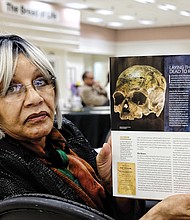 Evelyn Hawkins, a retired John Marshall High School librarian, shows the current edition of National Geographic magazine and the skull now being analyzed at the Smithsonian. Mrs. Hawkins' family now owns the  Southampton County farm where Nat Turner was captured after the enslaved people’s uprising in 1831.