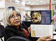 Evelyn Hawkins, a retired John Marshall High School librarian, shows the current edition of National Geographic magazine and the skull now being analyzed at the Smithsonian. Mrs. Hawkins' family now owns the  Southampton County farm where Nat Turner was captured after the enslaved people’s uprising in 1831.