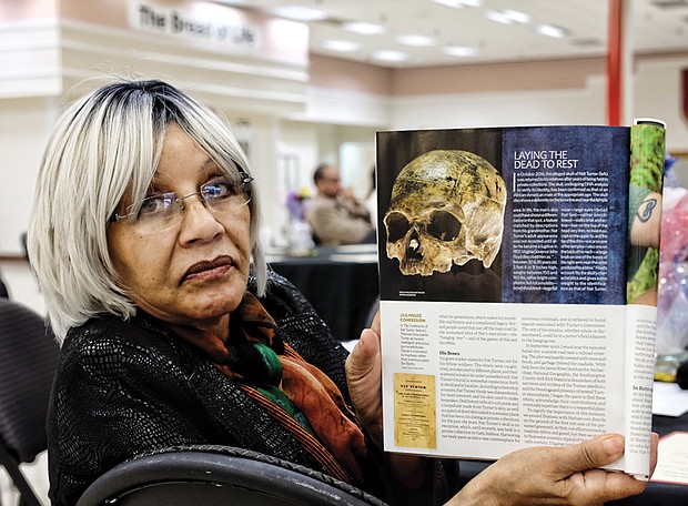 Evelyn Hawkins, a retired John Marshall High School librarian, shows the current edition of National Geographic magazine and the skull now being analyzed at the Smithsonian. Mrs. Hawkins' family now owns the  Southampton County farm where Nat Turner was captured after the enslaved people’s uprising in 1831.