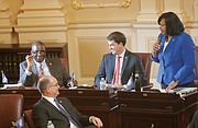 Petersburg Sen. Rosalyn R. Dance, right, introduces new Sen. Lionel Spruill Sr. of Chesapeake on the Senate floor.  Looking on are Sen. T. Montgomery “Monty” Mason of Williamsburg, front left, and Sen. Jeremy S. McPike of Woodbridge, center. 