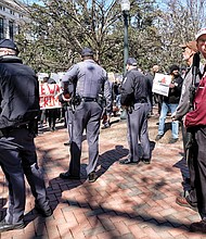 Who are the Capitol Police protecting? //

The noise was deafening last Saturday when an immigrant rights group held a rally in Capitol Square at the same time Republican gubernatorial candidate Corey Stewart held an “End Sanctuary Cities” rally espousing an opposite viewpoint. At least two of the Stewart supporters, one at right, openly carried military-style weapons and guns and stood just yards away from the ICE Out of RVA protesters. Capitol Police formed a line between the two groups, as shown here. But their backs were to the men carrying the weapons. Please see more photos, A5.