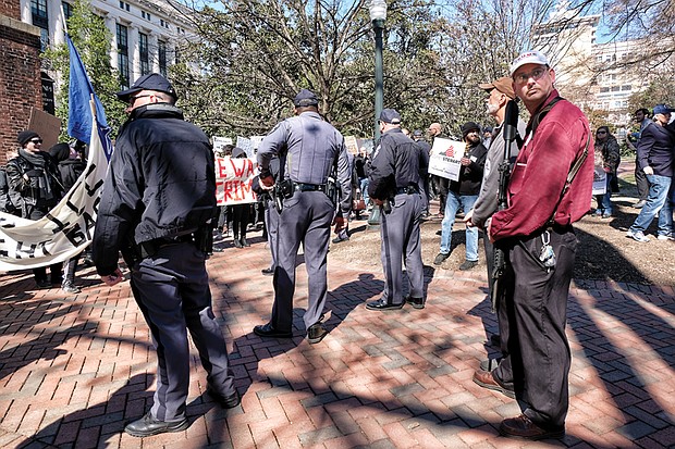 Who are the Capitol Police protecting? //

The noise was deafening last Saturday when an immigrant rights group held a rally in Capitol Square at the same time Republican gubernatorial candidate Corey Stewart held an “End Sanctuary Cities” rally espousing an opposite viewpoint. At least two of the Stewart supporters, one at right, openly carried military-style weapons and guns and stood just yards away from the ICE Out of RVA protesters. Capitol Police formed a line between the two groups, as shown here. But their backs were to the men carrying the weapons. Please see more photos, A5.