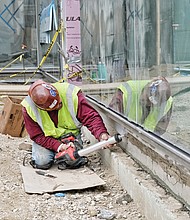 Fred Cueller works on the space where a café will be located. Right, workers install ductwork on the second floor of the building designed by Stephen Holl Architects, a New York-based firm. 
The $41 million, three-story building is set to open Oct. 28 and will feature a 240-seat auditorium for film screenings and live performances, an outdoor garden, a learning lab and flexible space for displays of modern paintings, sculpture and other works. 
