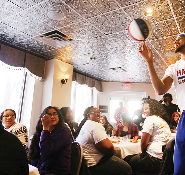 Zeus plays to crowd at Mama J’s //

Zeus McClurkin, a member of the legendary Harlem Globetrotters basketball team, captivates the room of 37 George Wythe High School honor students during a special luncheon Wednesday honoring the young people at Mama J’s Kitchen in Jackson Ward. The Columbus, Ohio, native engaged the students with a pep talk before showing off his skills. The event was part of Richmond’s first Black Restaurant Week highlighting black-owned and operated restaurants in the city. The promotion, with fixed-price lunch and dinner specials at 20 restaurants, runs through Sunday, March 12. Mr. McClurkin and the Harlem Globetrotters have an exhibition game 7 p.m. Friday, March 10, at the Richmond Coliseum.