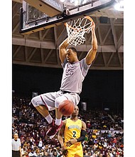 Kyle Benton of North Carolina Central University hangs from the rim after a slam dunk on Norfolk State University’s Zaynah Robinson in last Saturday’s championship game in the MEAC Tournament at the Norfolk Scope.