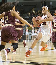 Megan Walker, center, of Chesterfield County’s Monacan High School gets through the defensive pack of King’s Fork High School of Suffolk to go in for the basket during Monacan’s 60-59 state 4A championship win last Friday at the Siegel Center in Richmond. Walker, the nation’s top-ranked high school player, is headed to the University of Connecticut, where she will play for the championship Huskies.