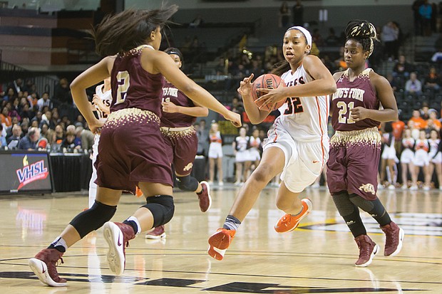 Megan Walker, center, of Chesterfield County’s Monacan High School gets through the defensive pack of King’s Fork High School of Suffolk to go in for the basket during Monacan’s 60-59 state 4A championship win last Friday at the Siegel Center in Richmond. Walker, the nation’s top-ranked high school player, is headed to the University of Connecticut, where she will play for the championship Huskies.