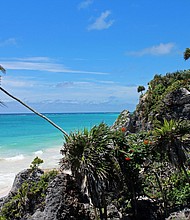 The country's tourism industry benefited from a weaker peso, which made hotel rooms and travel packages cheaper for foreign visitors. This photo was taken at the beach in Tulum, Mexico adjacent to the historic Mayan ruins. The lush vegetation, tall palm trees, fine white sand, and crystal clear turquoise water is what makes this a paradise worth exploring.