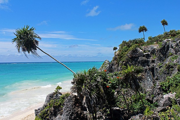 The country's tourism industry benefited from a weaker peso, which made hotel rooms and travel packages cheaper for foreign visitors. This photo was taken at the beach in Tulum, Mexico adjacent to the historic Mayan ruins. The lush vegetation, tall palm trees, fine white sand, and crystal clear turquoise water is what makes this a paradise worth exploring.