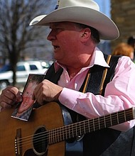 Kraig Moss, a supporter of Donald Trump during the campaign, sings a song outside a truck with a Trump painting last year in Iowa. Now, he regrets doing so.