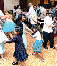 Father-daughter couples practice their salsa steps on the dance floor in the Massey Conference Center Auditorium at the garden’s Kelly Education Center.
