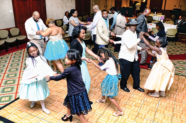 Father-daughter couples practice their salsa steps on the dance floor in the Massey Conference Center Auditorium at the garden’s Kelly Education Center.
