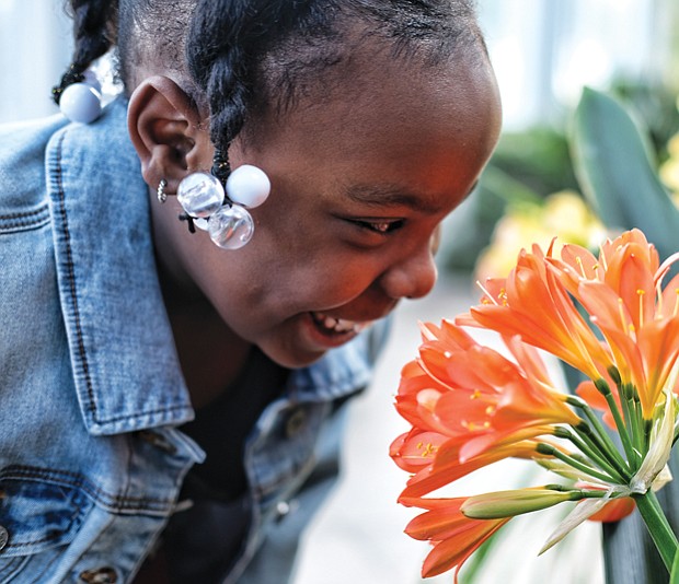 Smelling the flowers //
Aliyah Martin, 7, stops to smell a fire lily inside the Conservatory at Lewis Ginter Botanical Garden last Saturday during the Date with Dad event sponsored by the nonprofit Girls for a Change. Please see more photos, B2.
