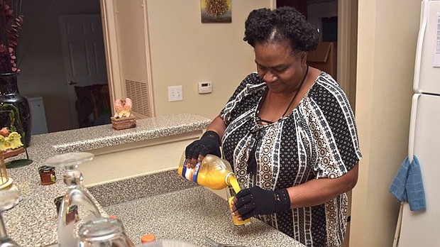 Martha Daniels pours juice in her kitchen that's provided by Meals on Wheels. Daniels, who's diabetic, receives meals each week that help manage her diabetes.
