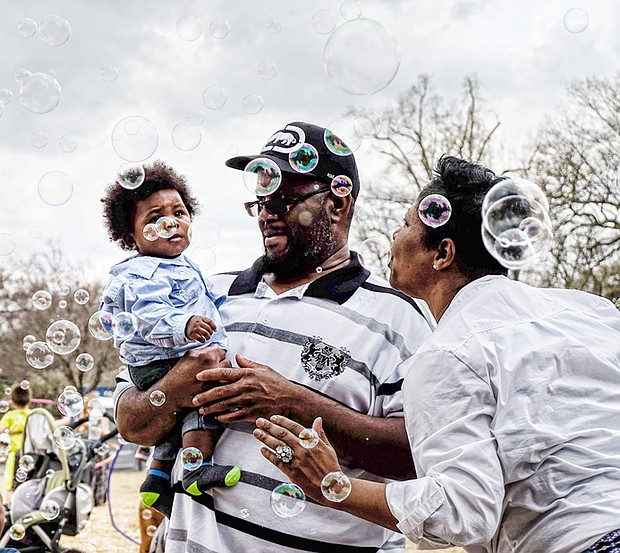 Bubbles, bubbles everywhere
Solomon and Sabrena Burison surround their 8-month-old son, Jacion, with a bevy of bubbles during the grand reopening of Maymont Farm last Sunday. The youngster carefully eyes the floating orbs. Please see more photos, B2. 
