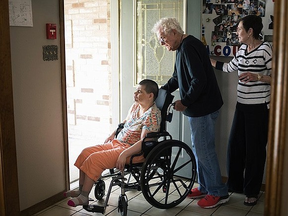 Dortha Biggs enters through the front door and rushes to greet her daughter, Lesli, who sits in a recliner, curled …
