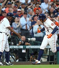 Houston Astros center fielder George Springer (4) celebrates with third base coach Gary Pettis (8) after hitting a home run during the first inning against the Seattle Mariners at Minute Maid Park. 