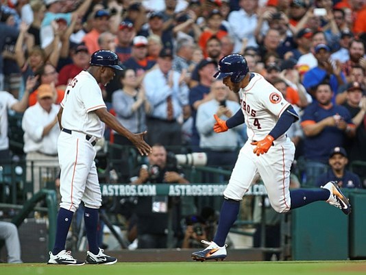 Houston Astros center fielder George Springer (4) celebrates with third base coach Gary Pettis (8) after hitting a home run during the first inning against the Seattle Mariners at Minute Maid Park. 