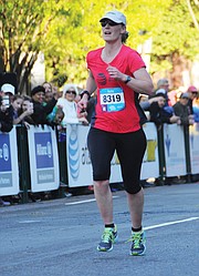 With a 2.6-mile head start, Dash for Cash runner Kathy Hoverman, right, makes her way to the finish line, where she beat the Monument Avenue 10K first place finisher and collected $2,500.
