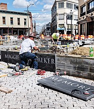 Cityscape // Wayne Floyd, left, and Jordan Wiles from Empire Granite work on the pedestal where the new statue of Richmond great Maggie L. Walker is to stand. The plaza at Broad and Adams streets is expected to be complete in four to six weeks. The bronze statue of Mrs. Walker “is finished,” sculptor Tony Mendez said Wednesday. It was completed two weeks ago, he said. He’s now awaiting instructions from the city about when it is to be delivered to the site. So far, City Hall has yet to announce a date for the dedication as officials work with the Mrs. Walker’s descendants on the timing. Mr. Mendez said there has been talk about holding the program on Saturday, July 15, Mrs. Walker’s birth date. This year would be the 153rd anniversary of the birth of the founder and president of the first bank to be chartered by an African-American woman. The total project cost: About $900,000.  