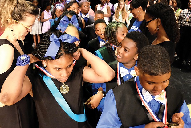 Masters of the dance // Fifth-grader Martierane Epps adjusts her medal, while Jahsai Fife admires his following Chimborazo Elementary School’s Blue Team winning 1st place Monday in the Dancing Classrooms GRVA Colors of the Rainbow Team Match. Students from Broad Rock, J.L. Francis, Falling Creek and E.S.H. Greene elementary schools in Richmond and Chesterfield County competed in the merengue, foxtrot, rumba, tango and swing at the event held at Huguenot High School in South Richmond. 