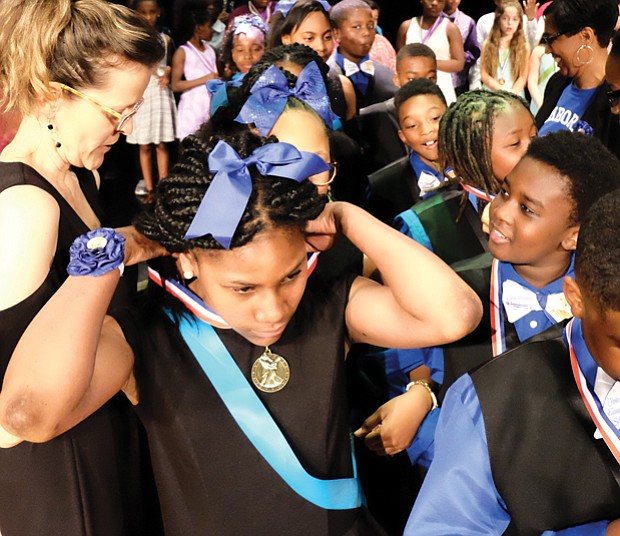 Masters of the dance // Fifth-grader Martierane Epps adjusts her medal, while Jahsai Fife admires his following Chimborazo Elementary School’s Blue Team winning 1st place Monday in the Dancing Classrooms GRVA Colors of the Rainbow Team Match. Students from Broad Rock, J.L. Francis, Falling Creek and E.S.H. Greene elementary schools in Richmond and Chesterfield County competed in the merengue, foxtrot, rumba, tango and swing at the event held at Huguenot High School in South Richmond. 