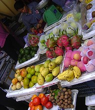 A fruit vendor sells her tropical specialities, like cherimoya, lychee and dragon fruit, at an open air market in Hoi An, Vietnam.