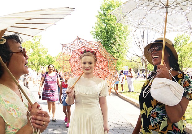 See and be seen  at Easter on Parade // three members of the Art Deco Society of Virginia, from left, Rita Shiang of Richmond, Anna Quilie of Carson and Christina Stewart-York of Chesterfield, draw admiring stares and some mutual admiration for their decorative parasols. 
