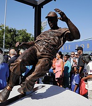 Fans, family and friends of baseball legend Jackie Robinson admire the statue of him stealing home base during last Saturday’s unveiling outside Dodger Stadium in Los Angeles. This year marks the 70th anniversary of Robinson’s historic breaking of the color barrier in Major League Baseball. 