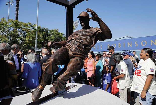 Fans, family and friends of baseball legend Jackie Robinson admire the statue of him stealing home base during last Saturday’s unveiling outside Dodger Stadium in Los Angeles. This year marks the 70th anniversary of Robinson’s historic breaking of the color barrier in Major League Baseball. 