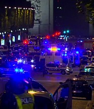 At least 20 police vehicles line the streets of the scene of a shooting in the Champs-Elysees area in Paris.