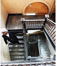 Margaret Stallings walks down the original wooden staircase inside the 114-year-old St. Luke building at 900 St. James St., which still has many of the coveted features of the city’s older buildings. 
