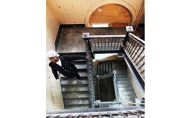 Margaret Stallings walks down the original wooden staircase inside the 114-year-old St. Luke building at 900 St. James St., which still has many of the coveted features of the city’s older buildings. 
